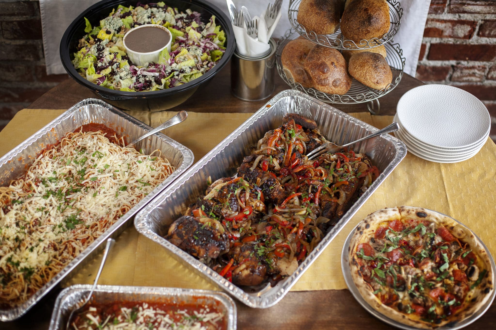 pasta, chicken, salads in catering trays on table